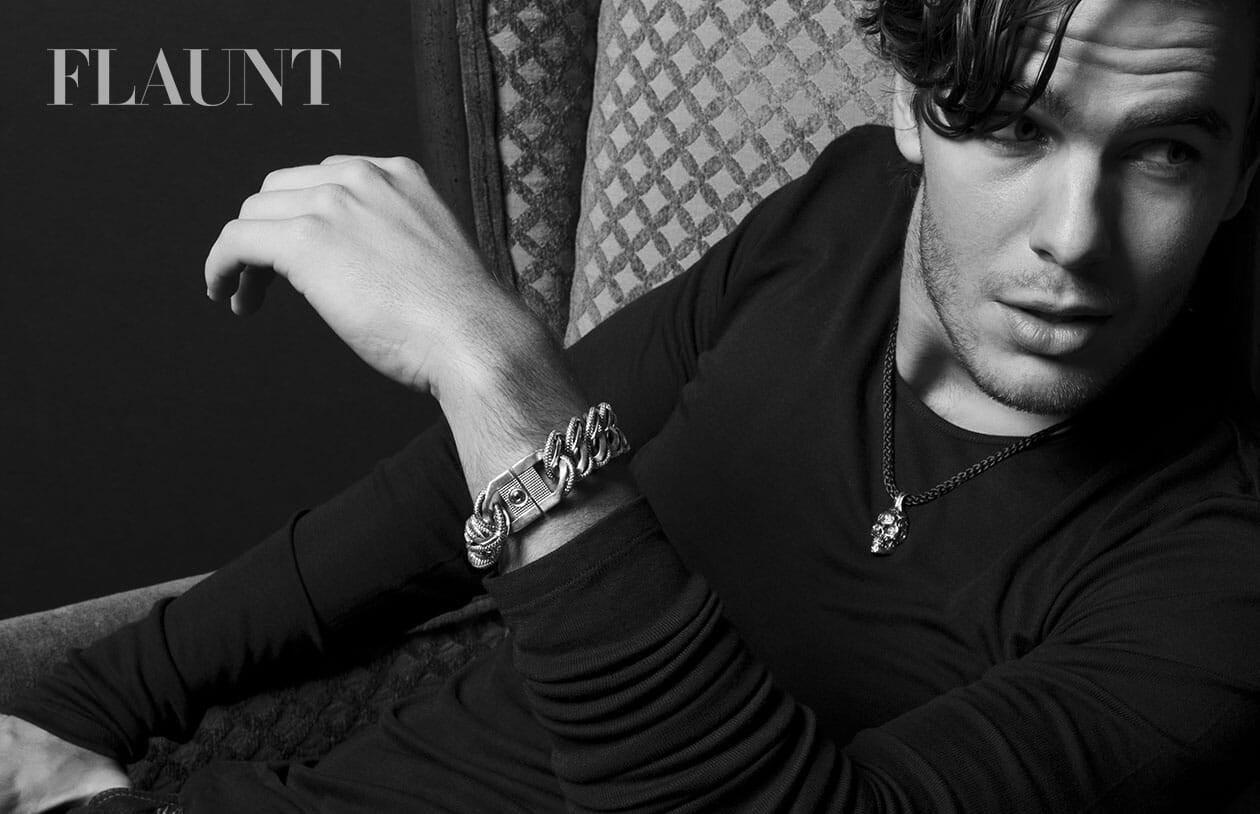 Silver-toned braided chain link bracelet and skull pendant necklace worn by a man.