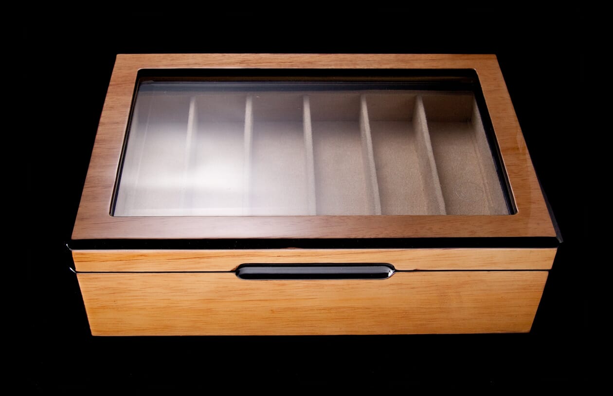 Light brown wooden collector display case with a clear glass lid, black trim, a sleek front groove, and six felt-lined compartments.