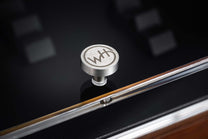 A Signature collector’s Box showing a brushed metal knob with a WH logo and a polished chrome handle on a dark surface.