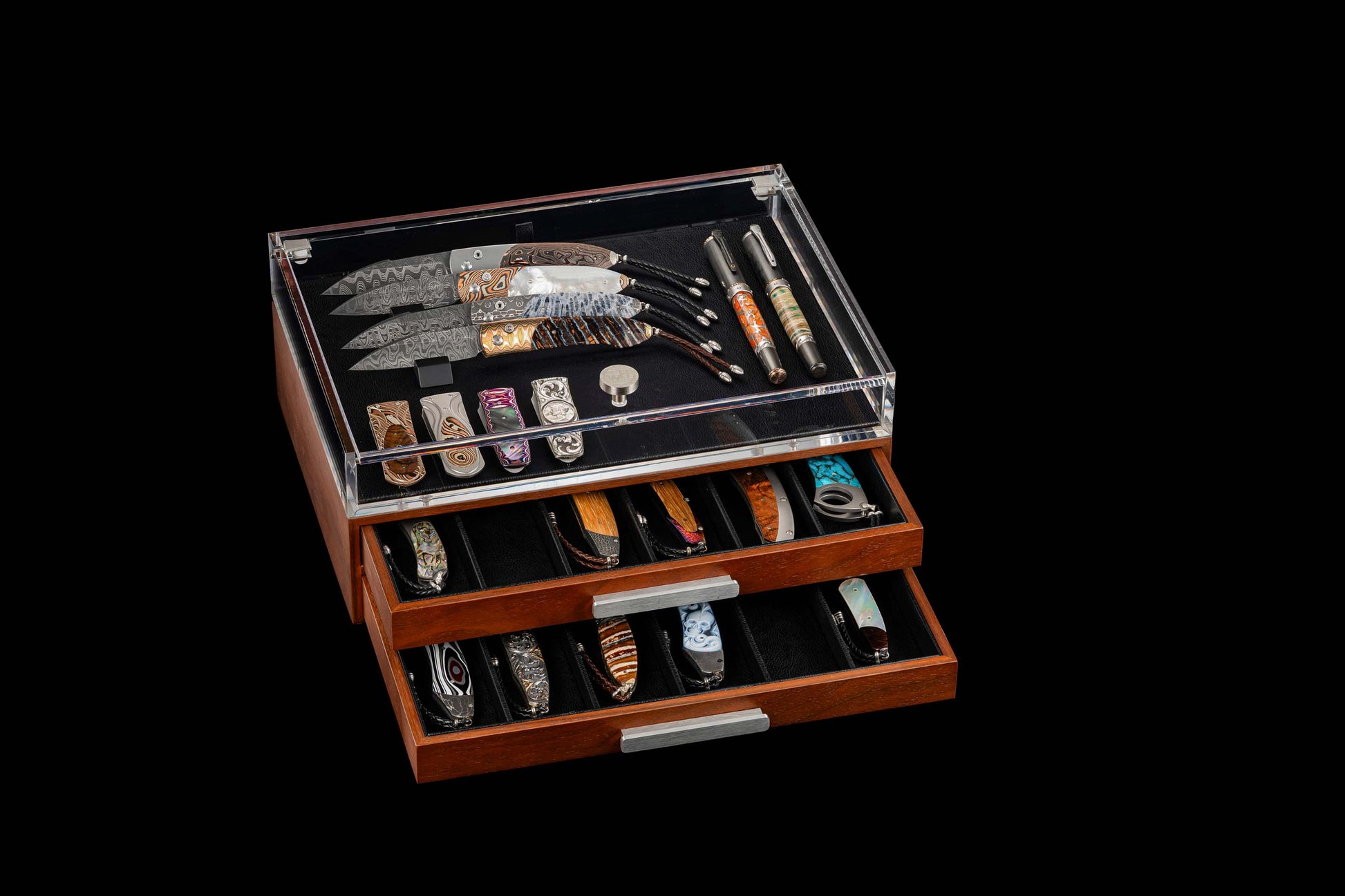 Wooden collector's box with clear acrylic top displaying custom knives, money clips, and pens in open drawers.