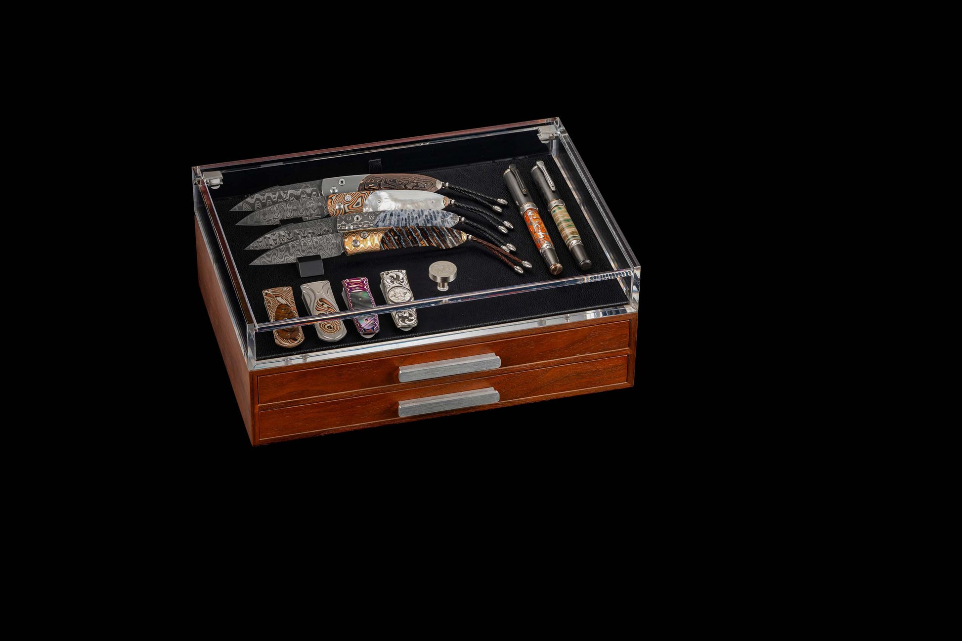 Signature wooden collector's box with clear lid, featuring four Damascus knives, two ornate pens, five decorative clips, and two drawers.