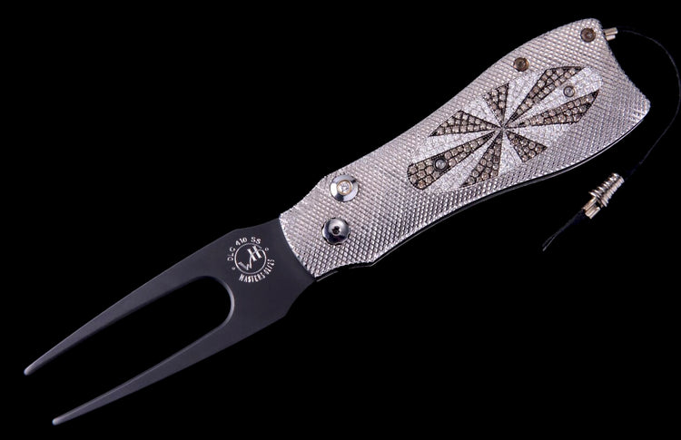 Luxury golf divot tool with silver textured handle, starburst pattern of clear and brown diamonds, and black fork.