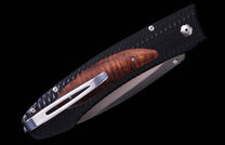 Folding knife with a black textured handle, a wavy brown wood inlay, and a silver pocket clip.