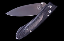 Dark grey folding knife by WH, half-open with a textured handle, polished blade marked "E6-3", and diamond accent.