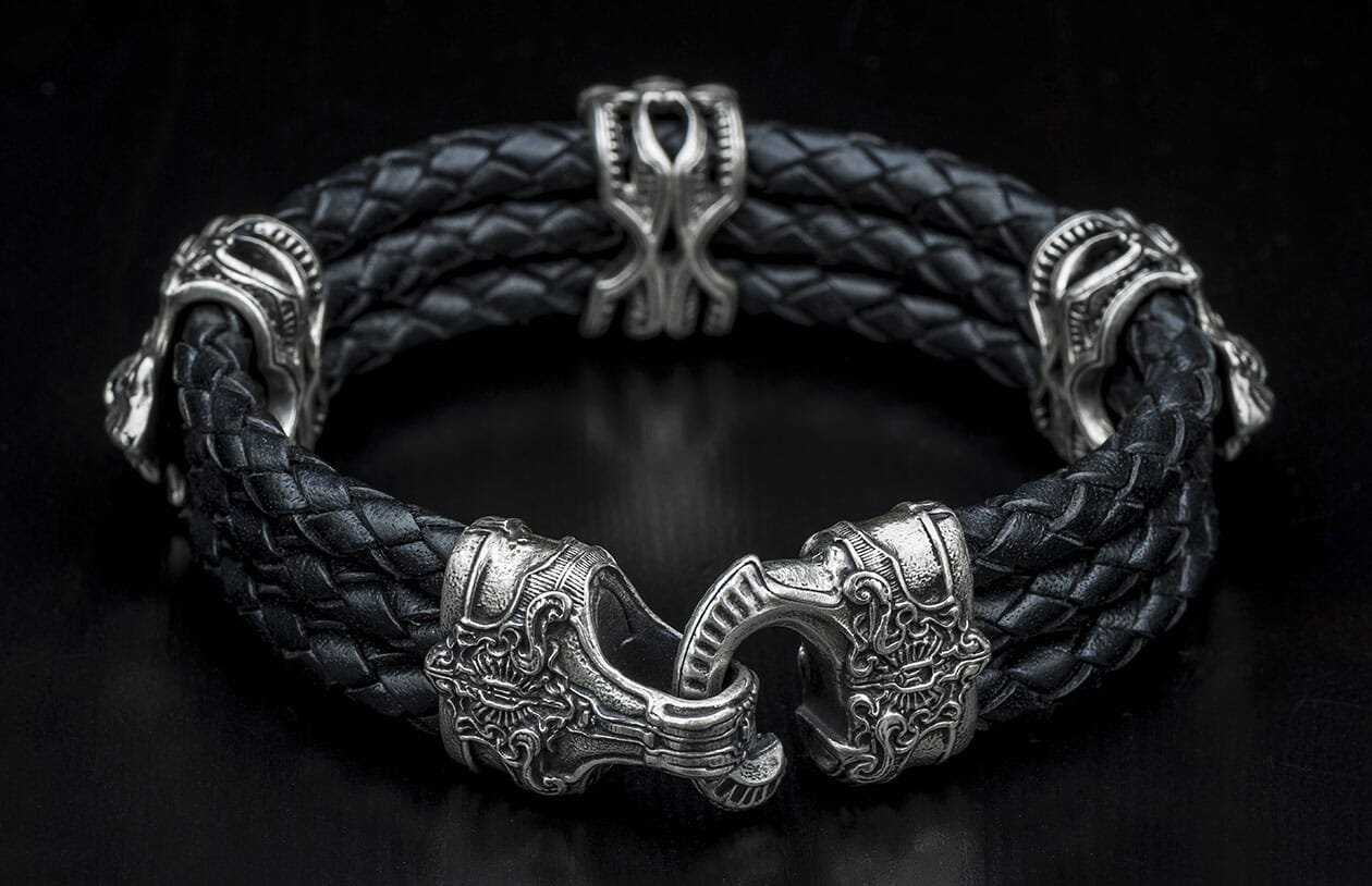 Black braided leather bracelet with ornate silver-toned warrior-themed metal beads and a detailed hook clasp.