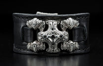 Black leather bracelet featuring an ornate silver centerpiece with black gemstones and intricate ram head side accents.