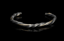 Twisted silver bracelet on a black background