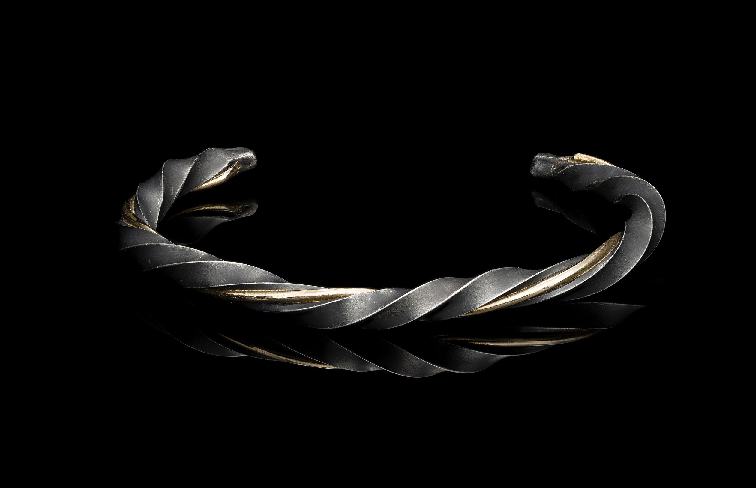 Twisted silver bracelet on a black background
