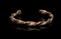 Twisted metal bracelet on a black background