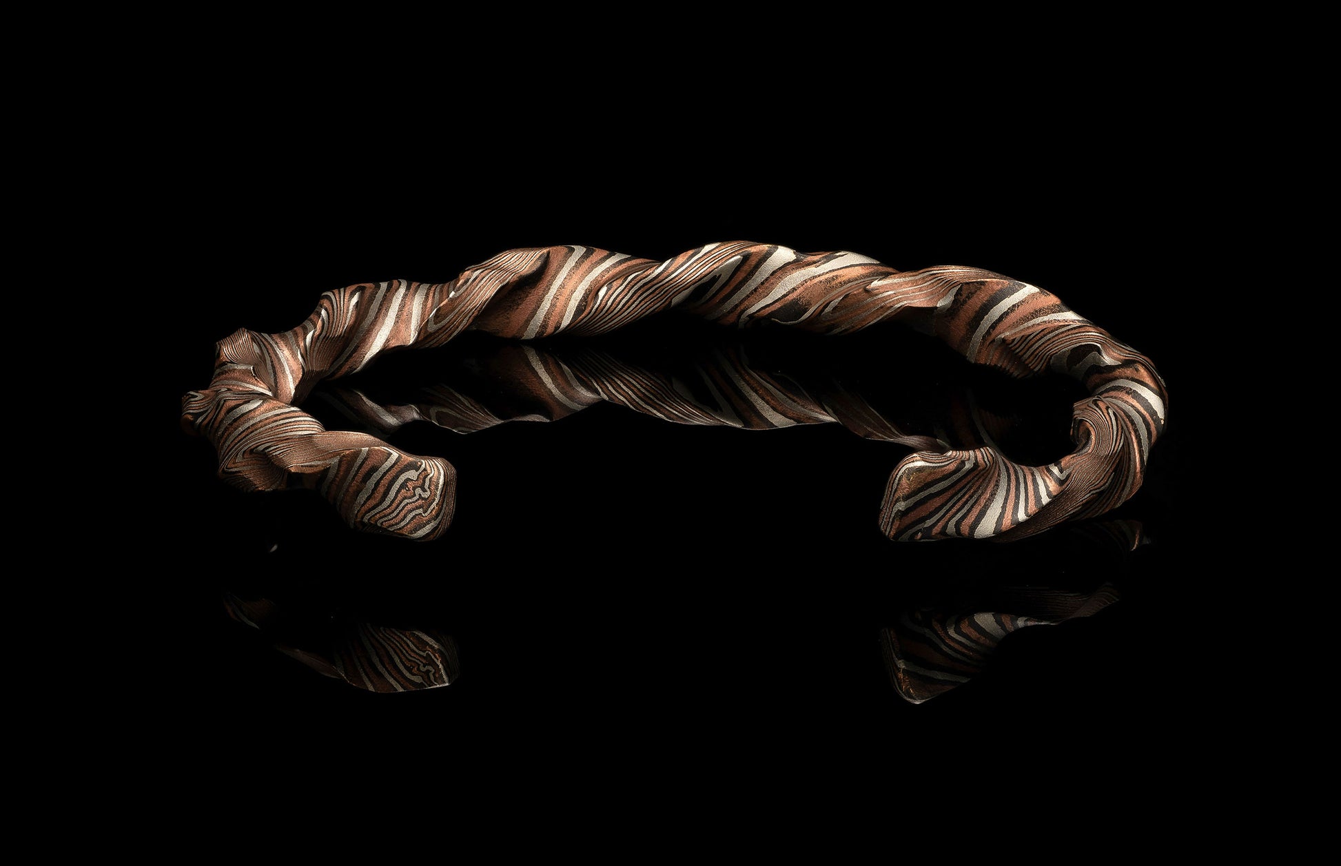 Twisted metal bracelet on a black background