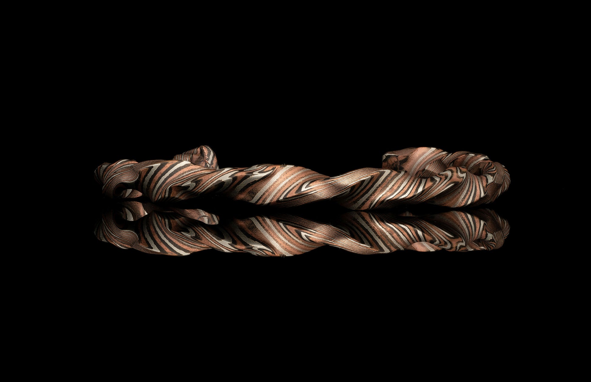 Twisted metal bracelet on a black background