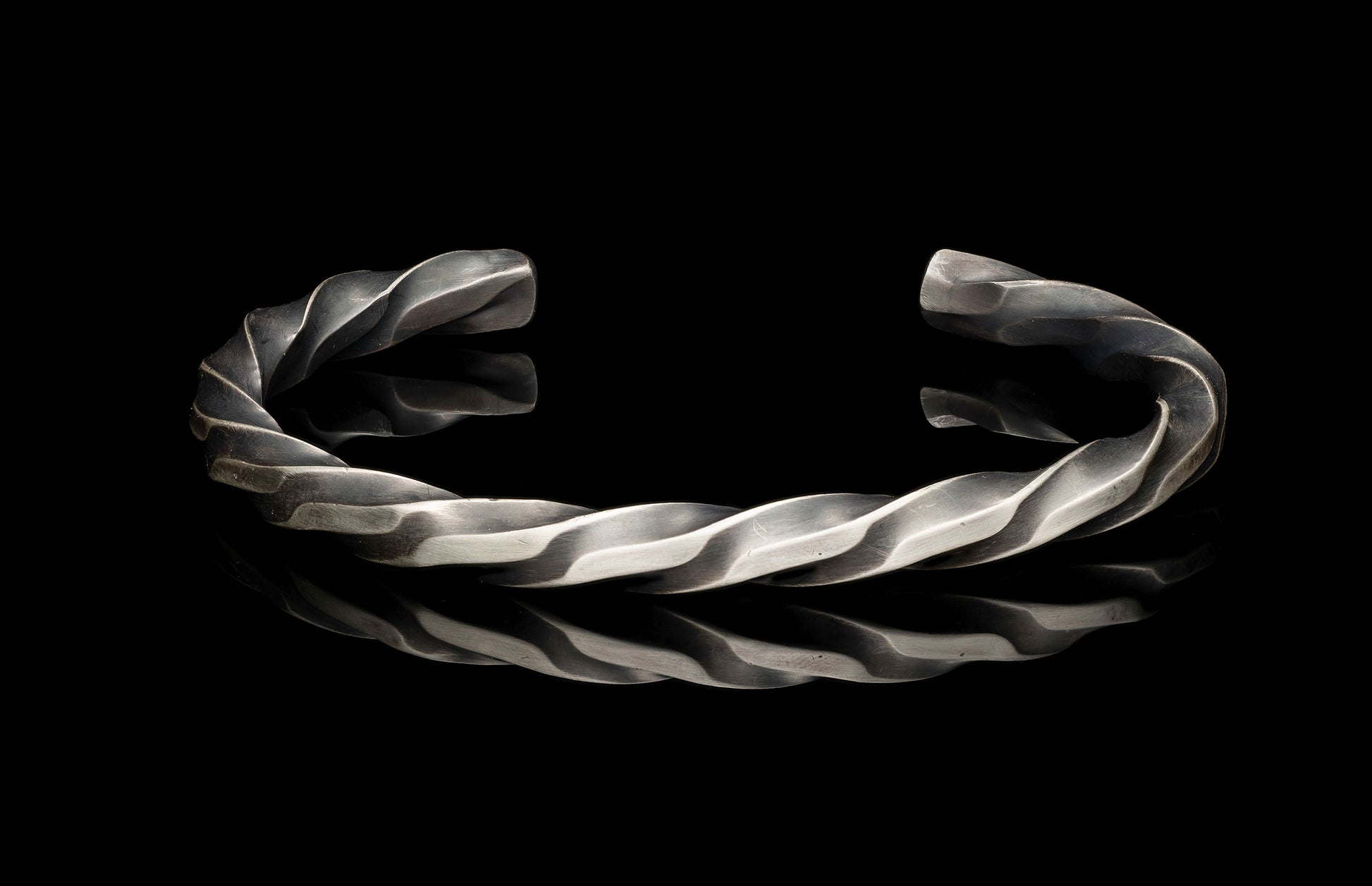Silver twisted bracelet on a black background