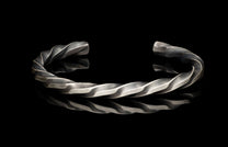 Silver twisted bracelet on a black background