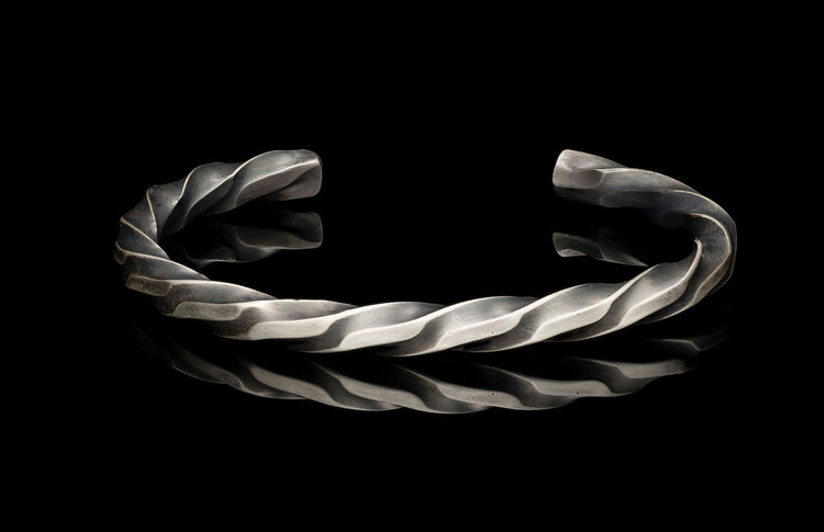 Silver twisted bracelet on a black background