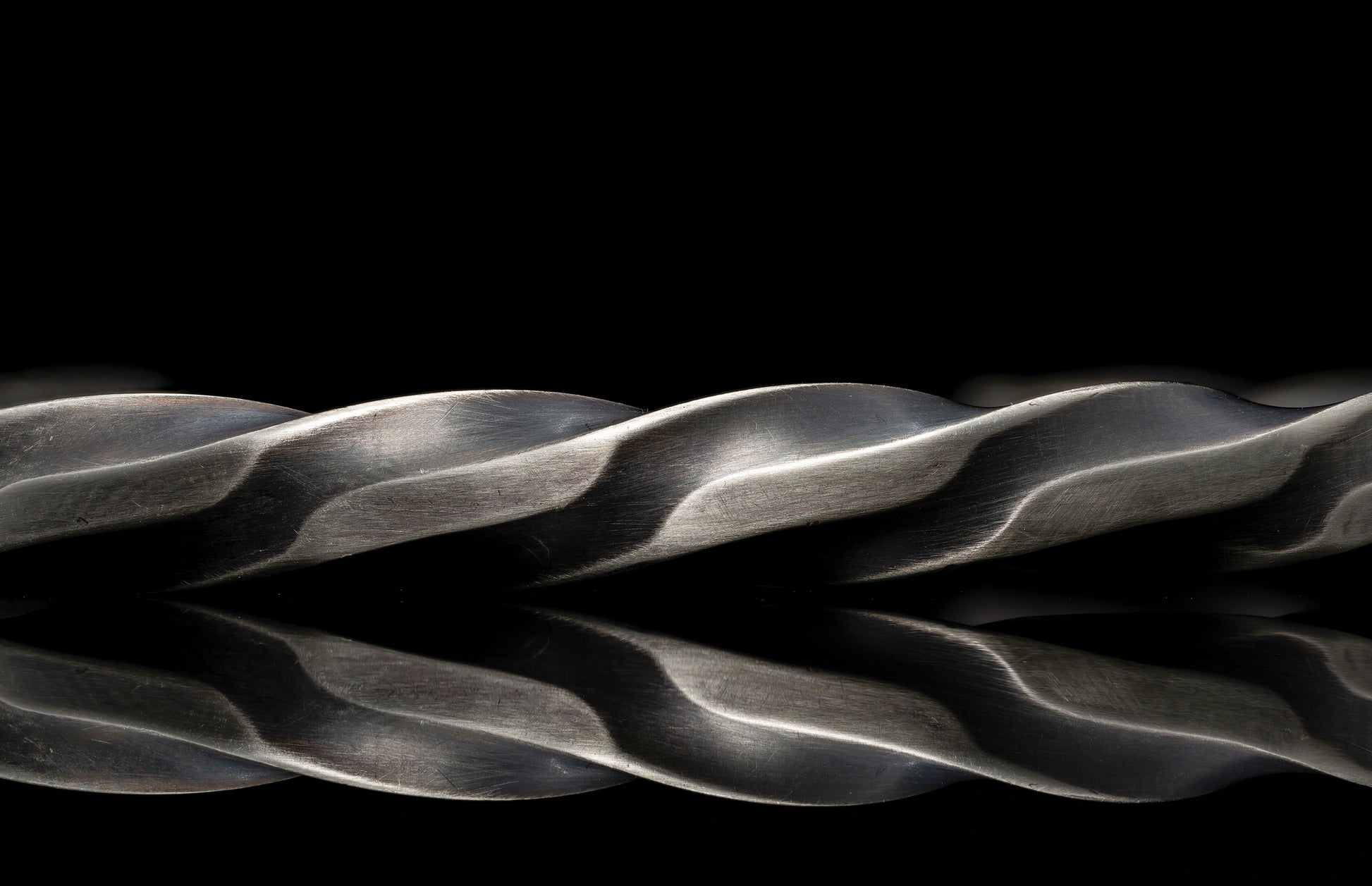 Close-up of a braided metal rope on a black background