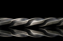 Close-up of a braided metal rope on a black background