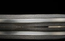 Close-up of metal bracelet with textured surface on a black background