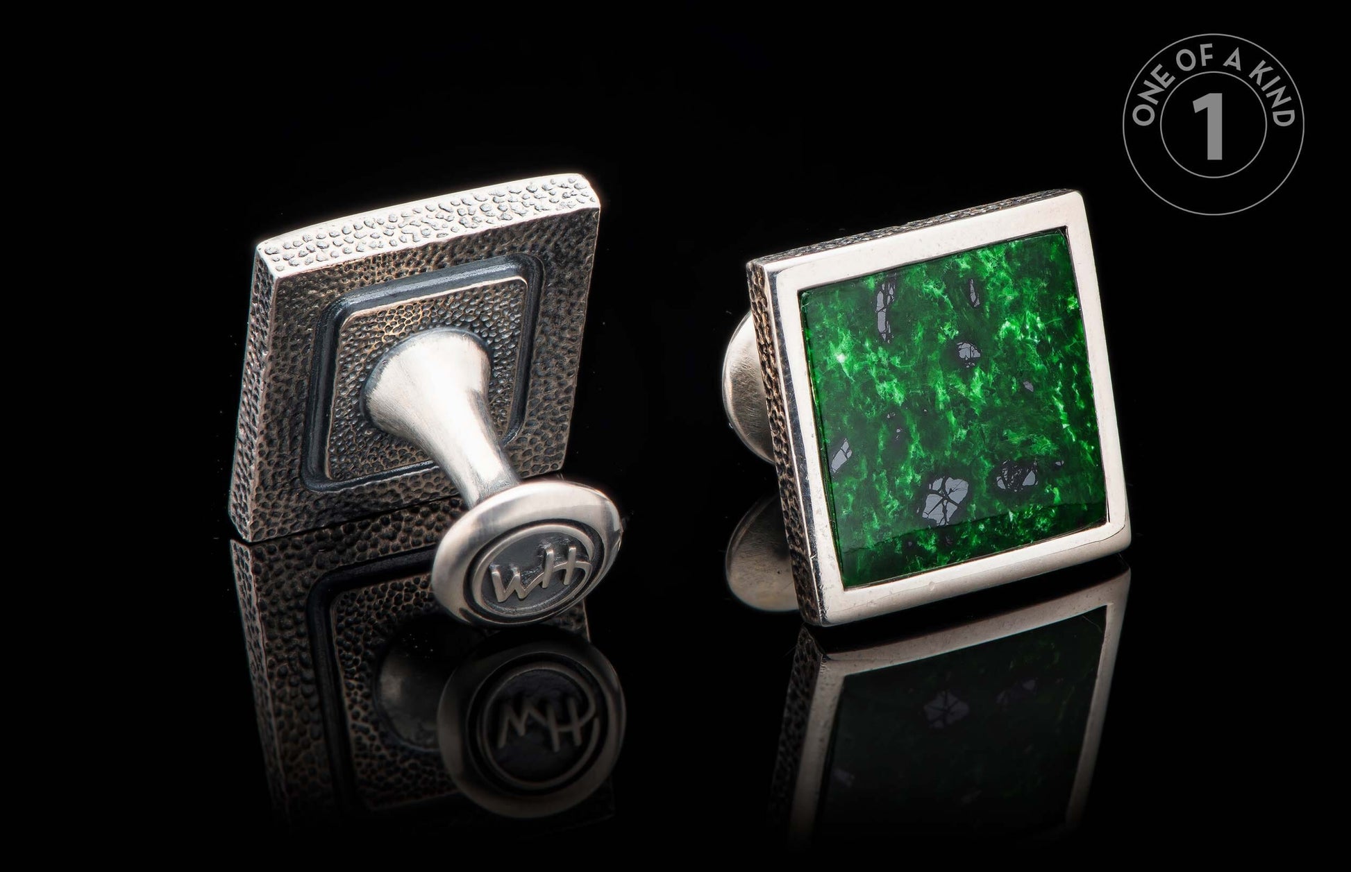 Silver-toned cufflinks, one with hammered texture and 'WH' monogram, the other with a square green stone.