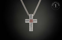 Silver cross pendant with a textured pattern and red gemstones in the center, hanging from a curb chain.