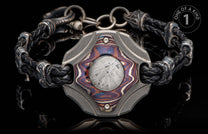 Black braided leather and ornate metal bracelet with a central plaque featuring a colorful inlay and meteorite pattern.