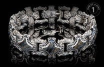 Intricately designed silver bracelet with hammer motifs and natural stone inlays.