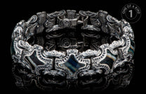 Silver-toned ornate bracelet with intricate embossed patterns, dark iridescent stone inlays, and visible 'HM' initials.