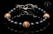 Black beaded bracelet with three patterned brown and white stone beads and an ornate silver hook clasp.