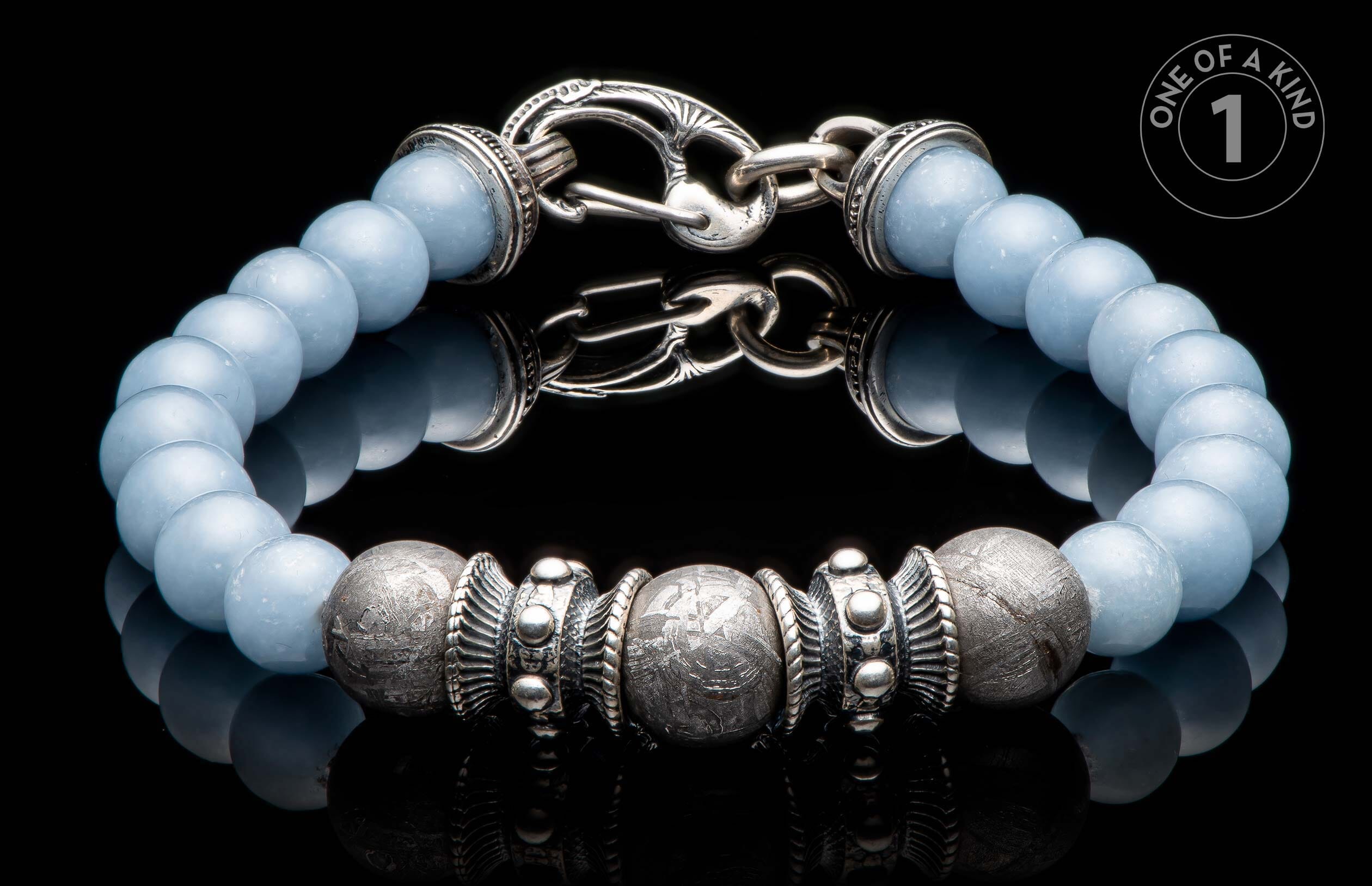 Light blue beaded bracelet with textured silver-toned beads, ornate metal spacers, and an intricate hook clasp.