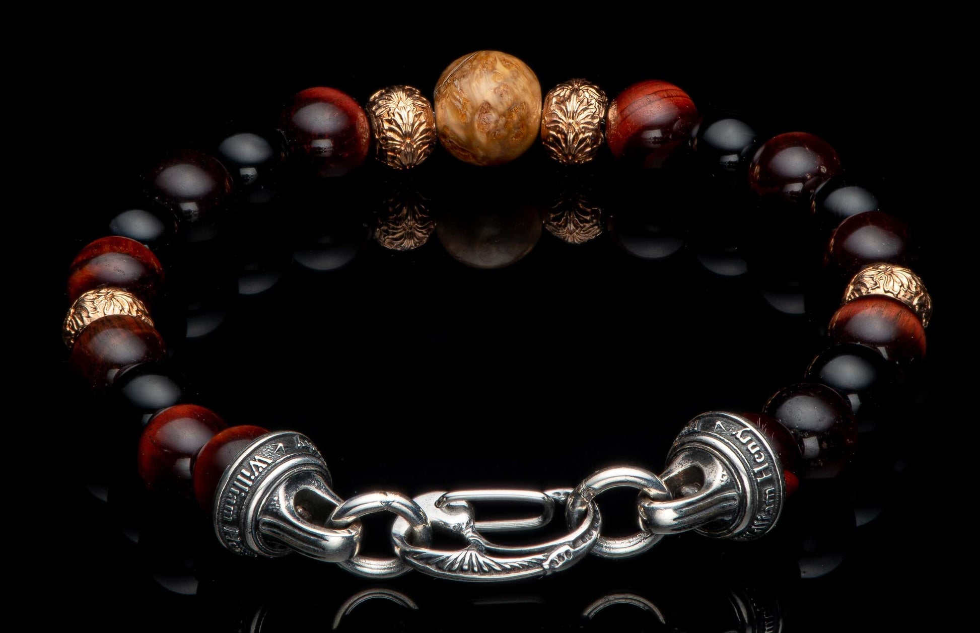 Beaded bracelet with red, black, and wood beads, gold-toned ornate spacers, and a silver clasp engraved with 'William Henry'.