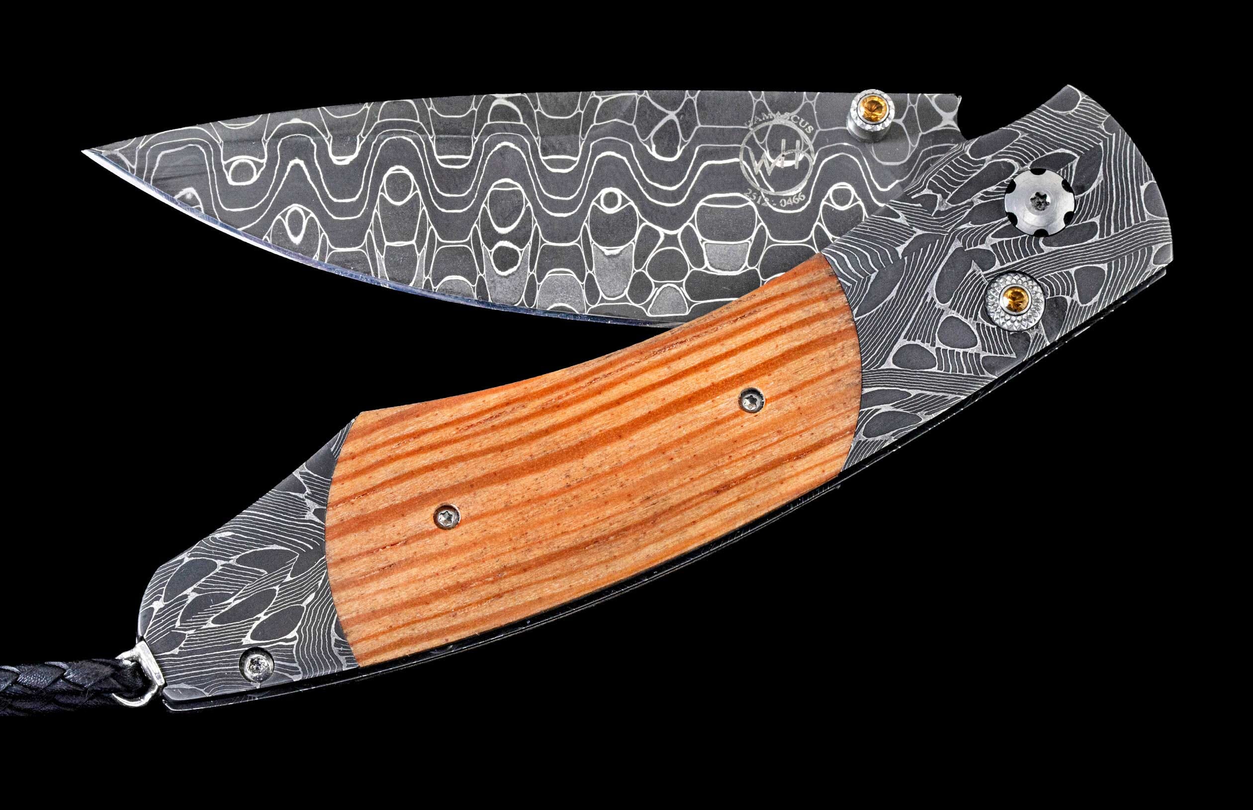 Partially open folding knife with Damascus steel blade and wooden handle by WH, featuring intricate patterns, gold-toned accents, and a braided leather lanyard.