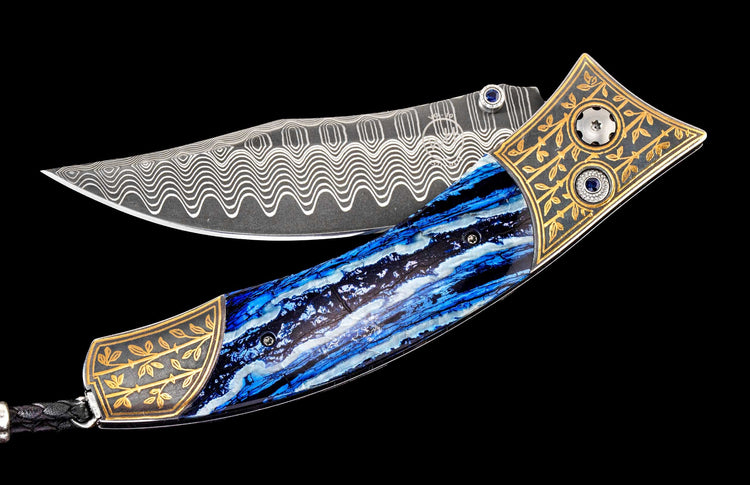 One of a kind William Henry custom knife with hand forged Damascus steel blade, 24K gold inlaid Koftgari, Fossil Mammoth tooth, and sapphire gemstones.