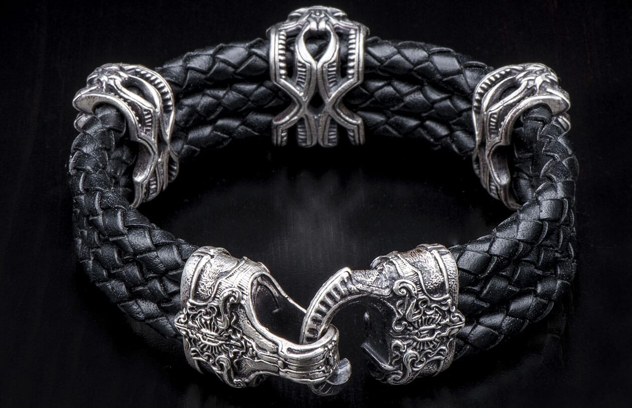 Black braided leather bracelet with elaborate silver-toned metal decorative beads and an intricately designed clasp.
