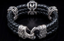 Black braided leather bracelet with elaborate silver-toned metal decorative beads and an intricately designed clasp.
