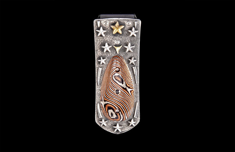 Silver-toned hammered money clip featuring a central teardrop inlay with wavy brown and white patterns, accented by silver and gold stars.