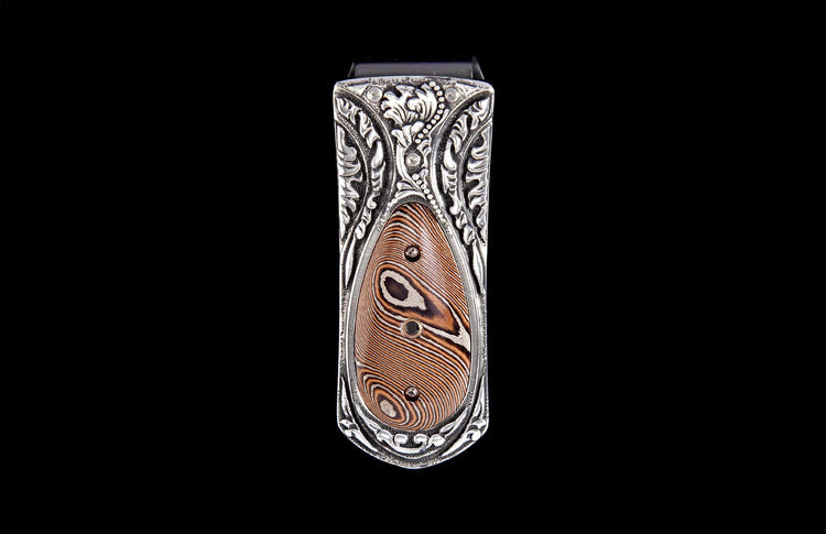 Money clip with ornate silver-toned engraved frame and a brown and silver striped inlay featuring black accents.