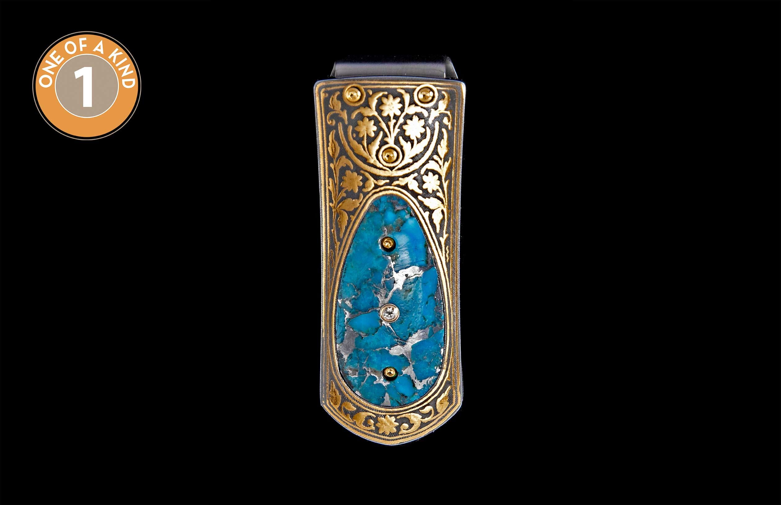Gold money clip with intricate scrollwork, featuring a large turquoise inlay with three embedded stones.