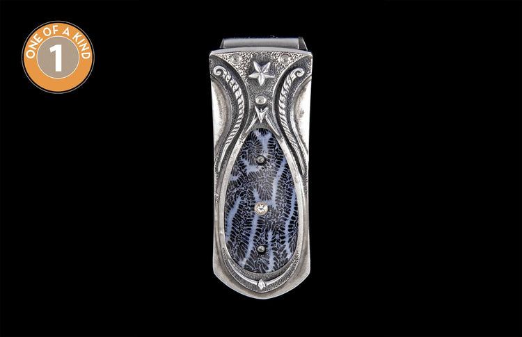 Silver metal money clip with black and white fossilized coral inlay, accented with a star, scrollwork, and three small diamonds.