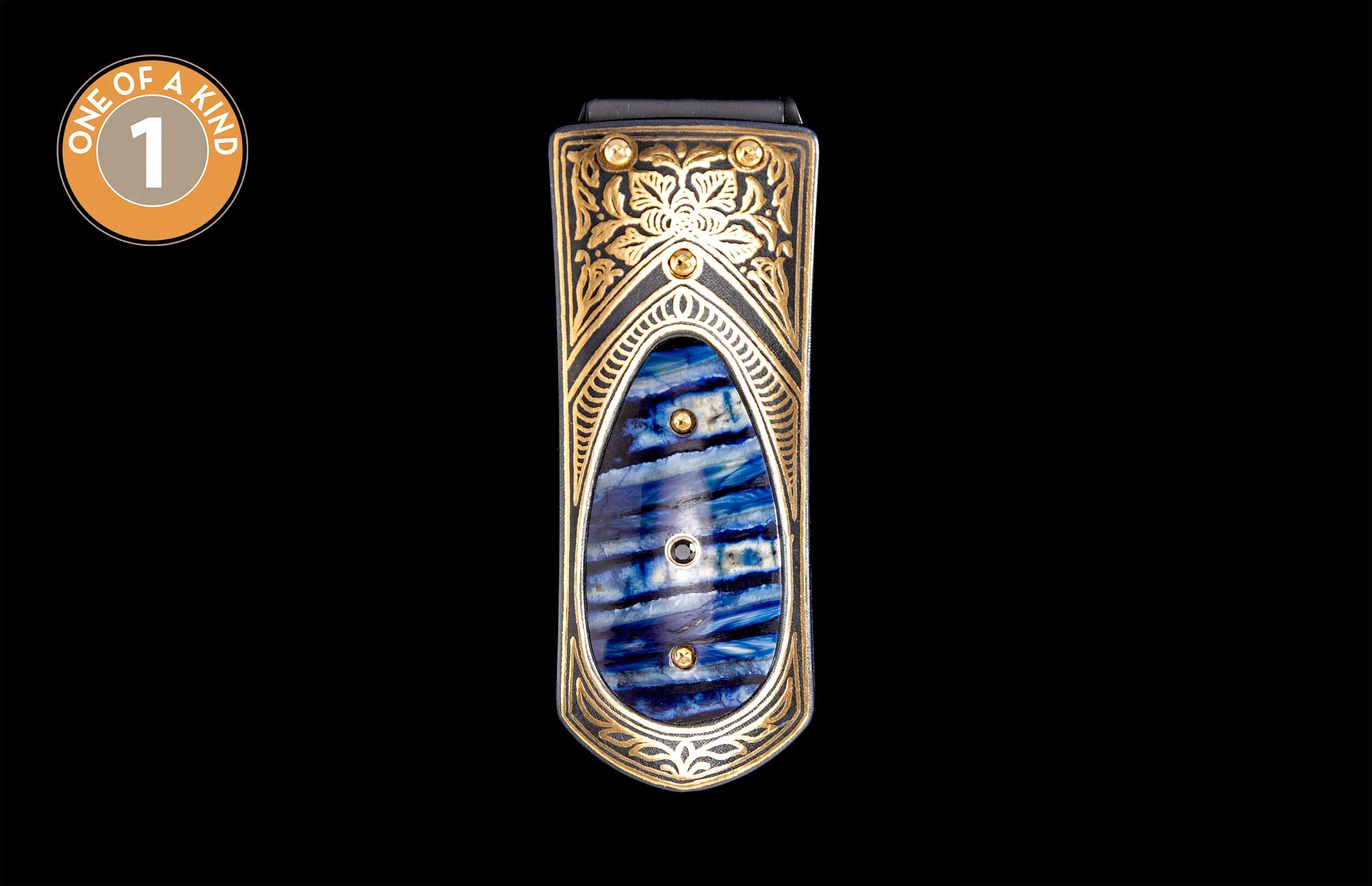 Black money clip with ornate gold scrollwork and a blue and white striped inlay, accented with studs.