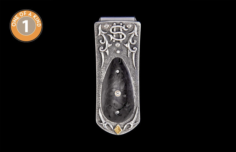 Ornate hammered silver money clip with a dark textured inlay, featuring three clear round diamonds and one square yellow diamond.