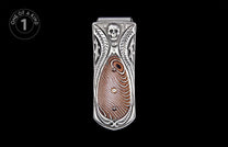 Silver money clip with an embossed skull, ornate carvings, and a brown Damascus patterned inlay with two gems.