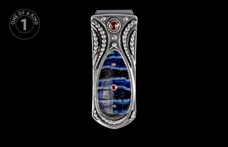 Silver money clip with intricate design, featuring a striped blue and black stone inlay and two small red gemstones.