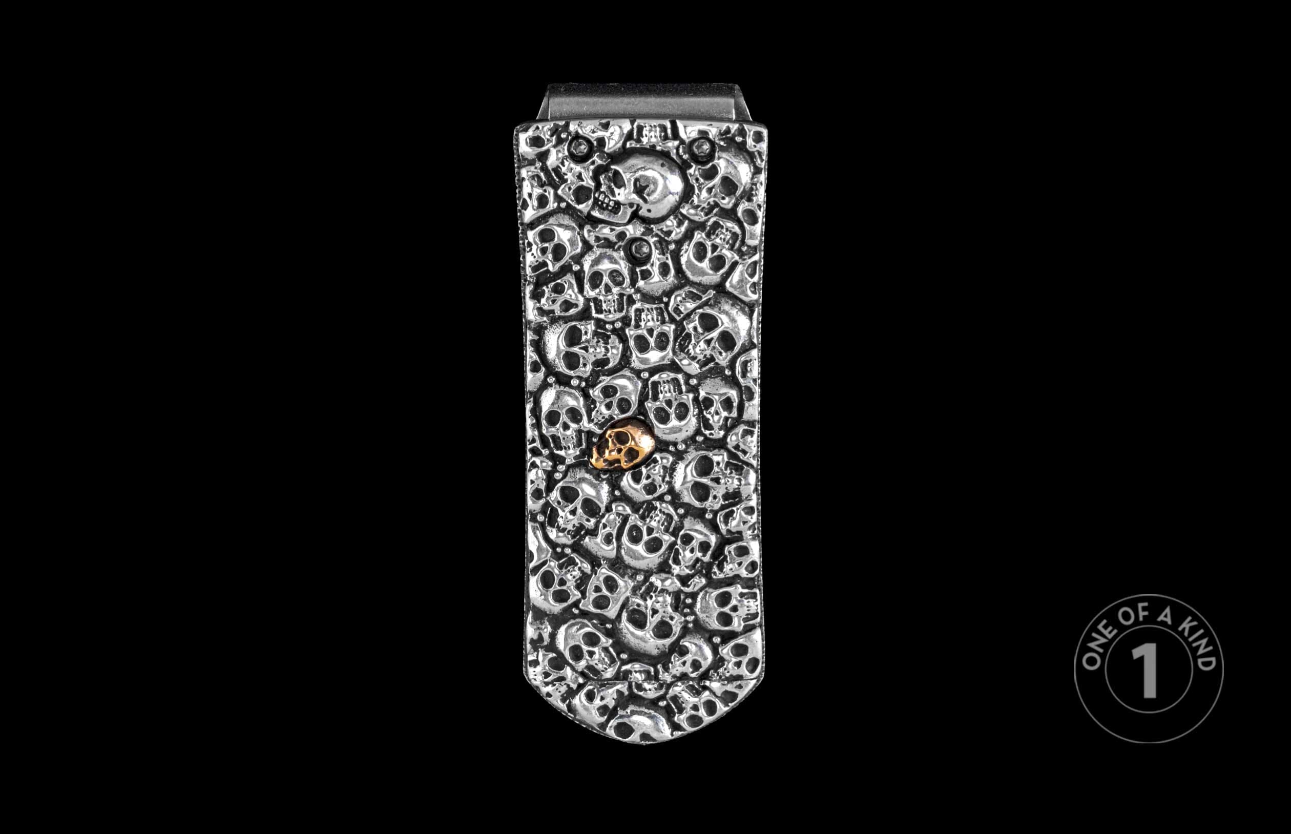 William Henry money clip featuring many hand carved skulls in sterling silver and one in gold