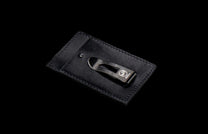 MCW MC BLK|Black leather card and cash wallet with a dark metal money clip featuring a logo and serial number, and visible stitching.