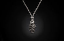 Silver braided necklace with a textured, tapered pendant featuring overlapping scale-like elements, against a black background.