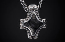 Distressed silver Mjolnir-style pendant featuring a stylized helmet and black textured inlay on a braided chain.