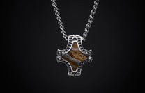 Braided silver-tone chain necklace with a textured metal pendant holding a brown and white layered stone.