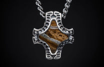 Textured silver-toned pendant featuring a brown and white banded stone inlay, suspended from a braided chain.