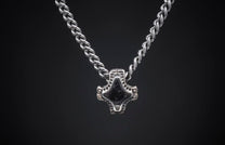 Silver braided chain necklace with a dark, intricately designed Mjolnir-style pendant on a dark background.