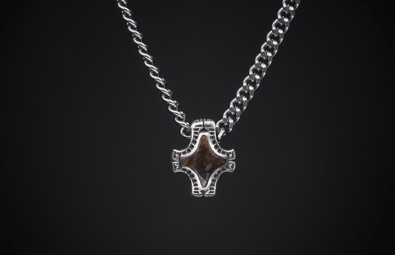 Silver necklace featuring two distinct chain styles and a stylized brown stone pendant.
