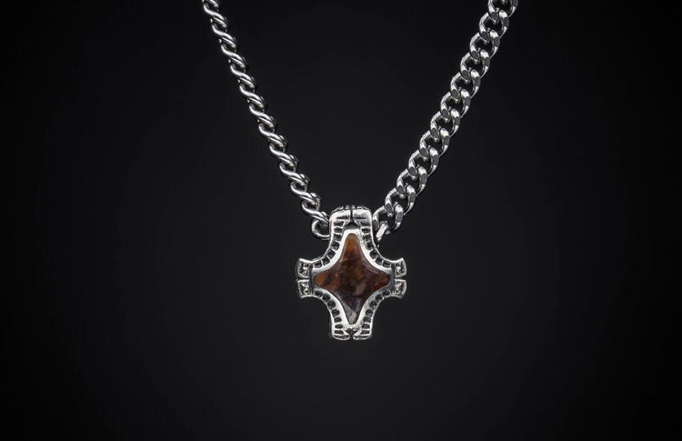 Silver necklace featuring two distinct chain styles and a stylized brown stone pendant.